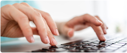 Hands typing on a laptop keyboard