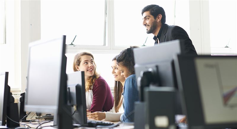 Team collaborating at computers in a bright office